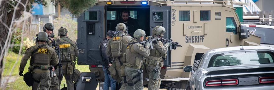 McKenna Members of the Humboldt County Sheriff’s Department SWAT team take cover behind a Bear Cat armored vehicle.