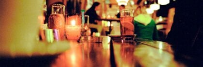 drink left on bar top, people in background