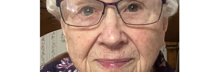 Woman with grey hair and glasses.