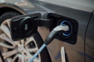 grey sedan hooked to ev charging station