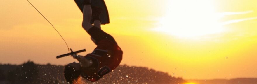 wakeboarder upside down against sunset sky