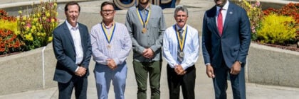 Five men dressed up standing on cement