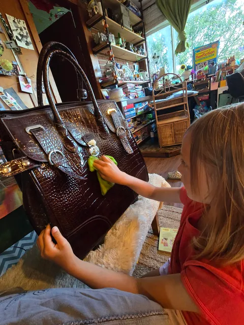 Teagan Clinton cleans the rolling travel bag she won during the Blocksburg Ice Cream Social auction, unaware that one of its pockets held a long-forgotten surprise. Photo courtesy of Jeni Stevens.