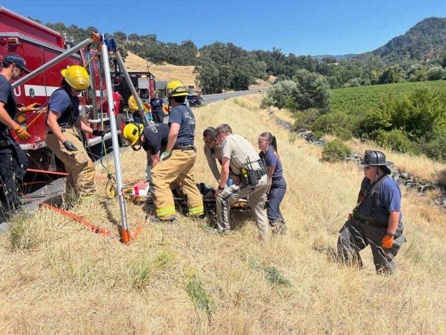 CHP officers and firefighters work to move an injured driver from a steep embankment after a solo-vehicle crash on southbound Highway 101 just south of Hopland Tuesday afternoon. [Photo from CHP]