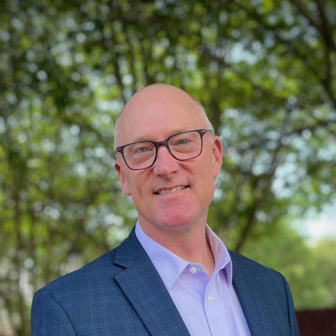 Headshot of man in glasses in a suit