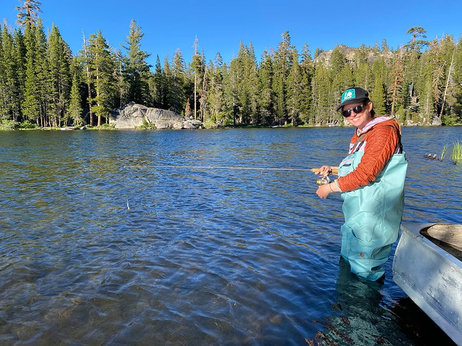 Person in waders fishing in lake